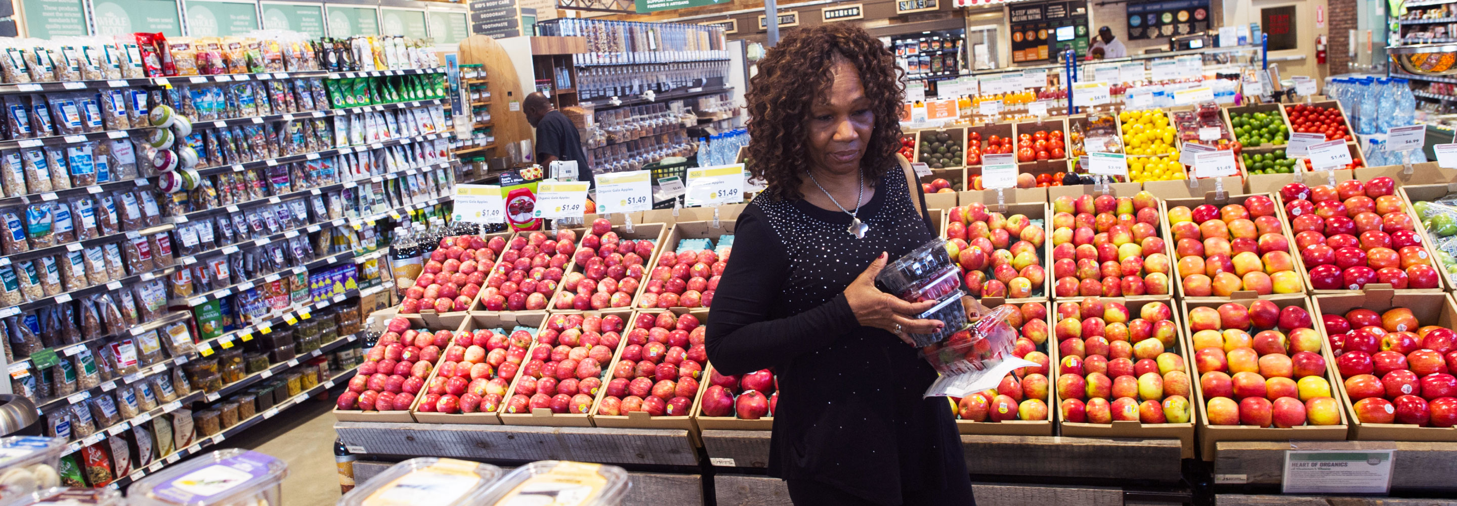 A woman shopping for produce in a grocery store.