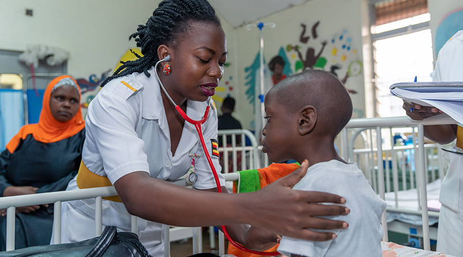 A nurse using a stethoscope to examine a young boy in a hospital.