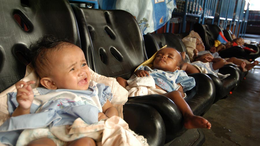 a row of babies in booster seats